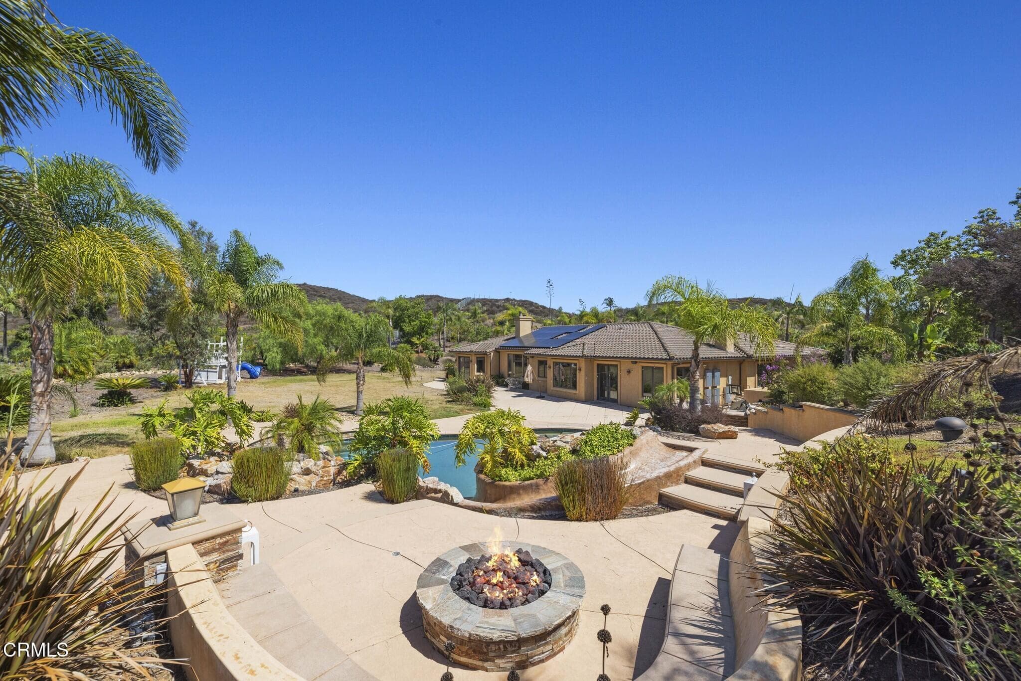 Fire pit lounge overlooking the pool, home and grounds